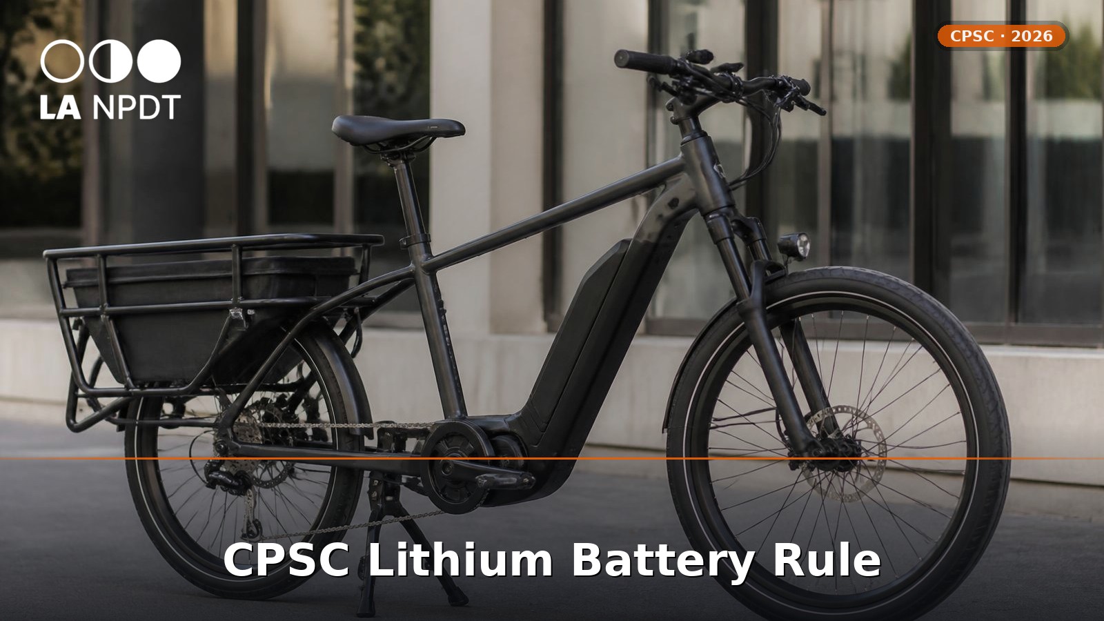 Matte black cargo e-bike with integrated lithium battery pack on a city sidewalk