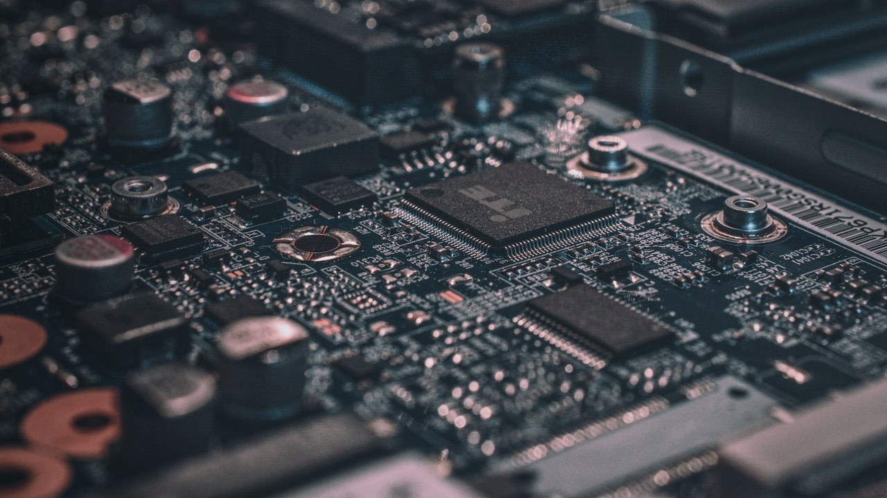 Close-up of a printed circuit board with advanced computing chips, illustrating Section 232 semiconductor tariff exposure for hardware founders reviewing a BOM.