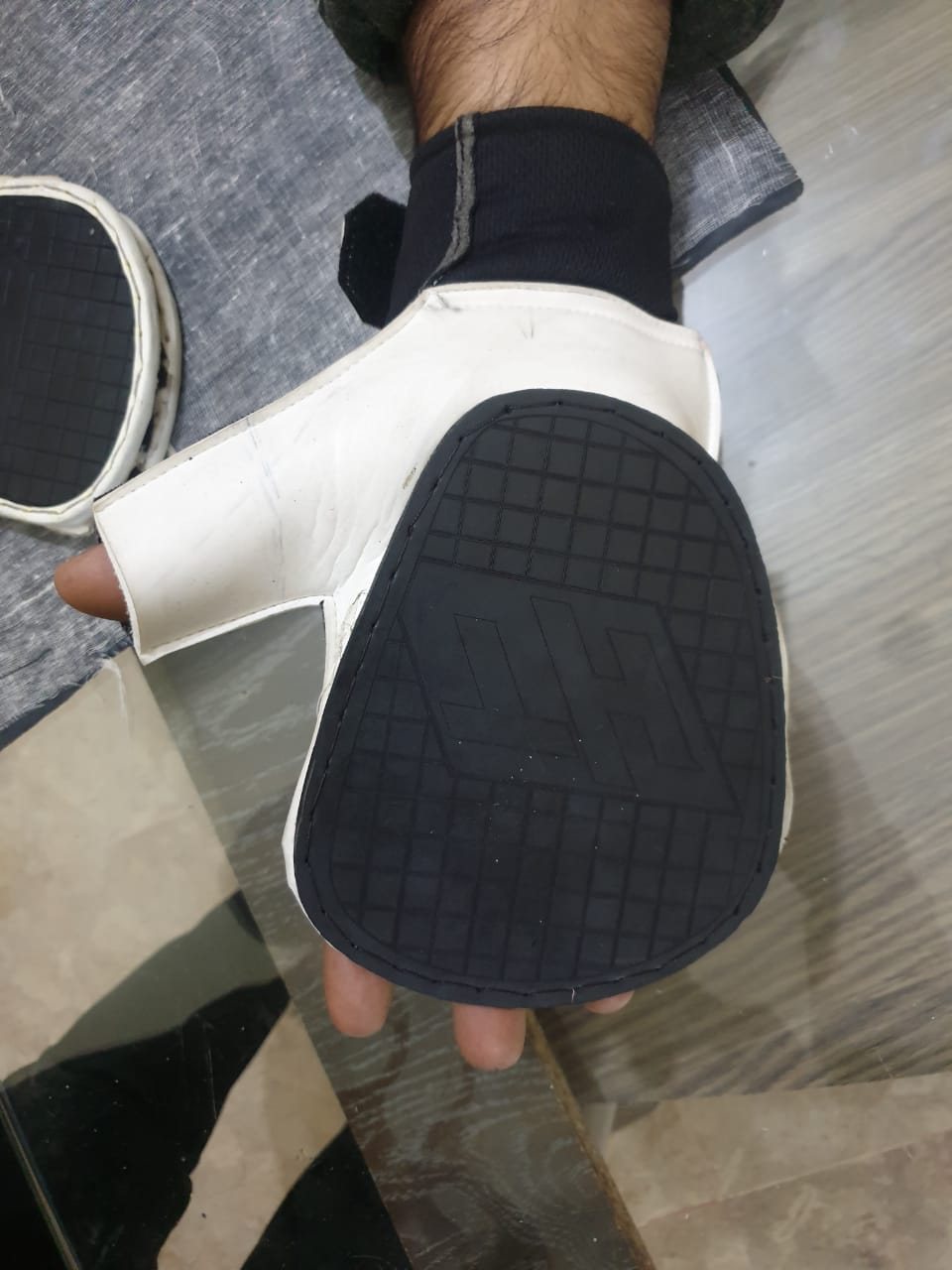 Early Hand Tennis prototype glove worn on the hand, showing pad coverage across the palm