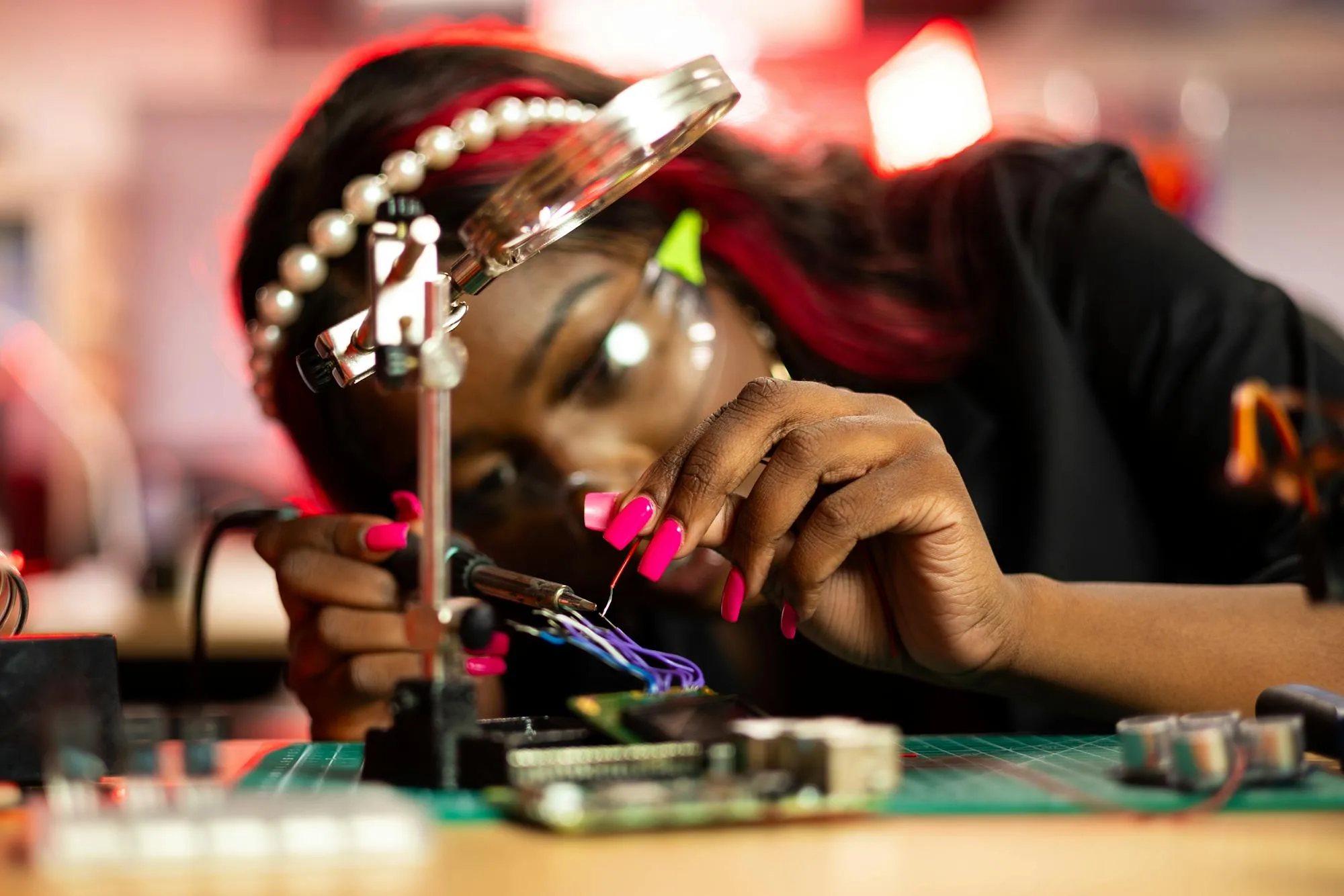 Cross-functional electronics team reviewing schematic and PCB on a workbench